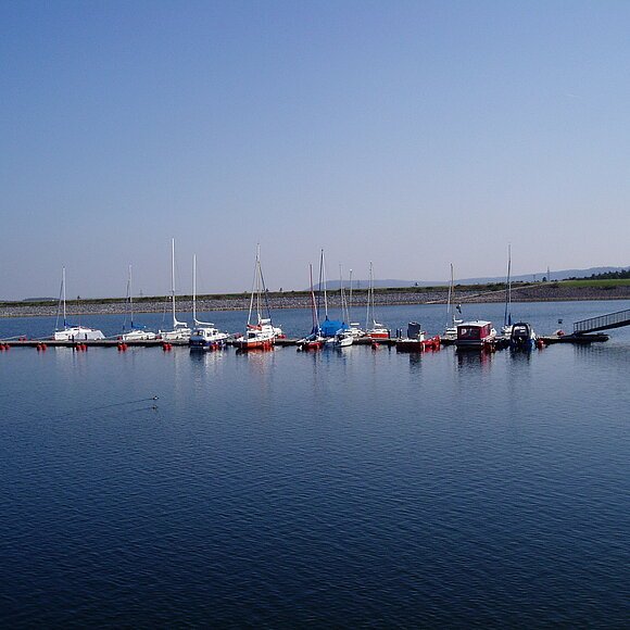 Ein Segelhafen im blauen See. Nur wenige Boote liegen im Hafen.