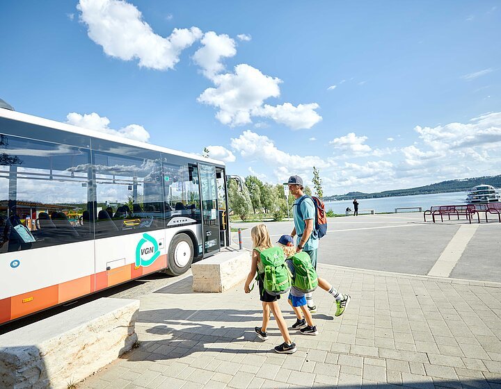 Auf dem Bild ist ein Bus der Seenlandlinie an der Freizeitanlage am Brombachsee zu sehen. Ein Vater mit 2 Kindern will gerade in den Bus steigen.
