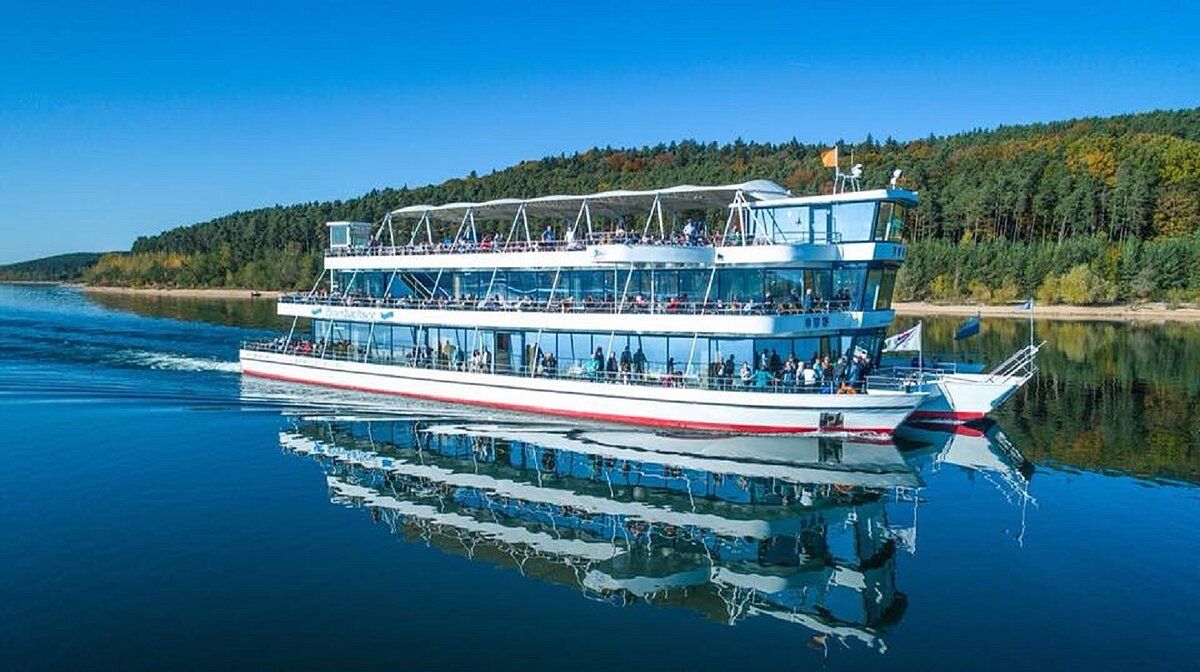MS Brombachsee Die MS Brombachsee fährt über den See. Am Ufer grüne Bäume und Sträucher.